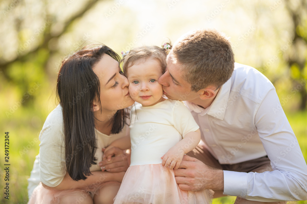 Love, happy family on vacation in a blooming garden in spring, summer. Cheerful mood and warm atmosphere Love, happy family on vacation in a blooming garden in spring, summer. Cheerful mood and warm atmosphere