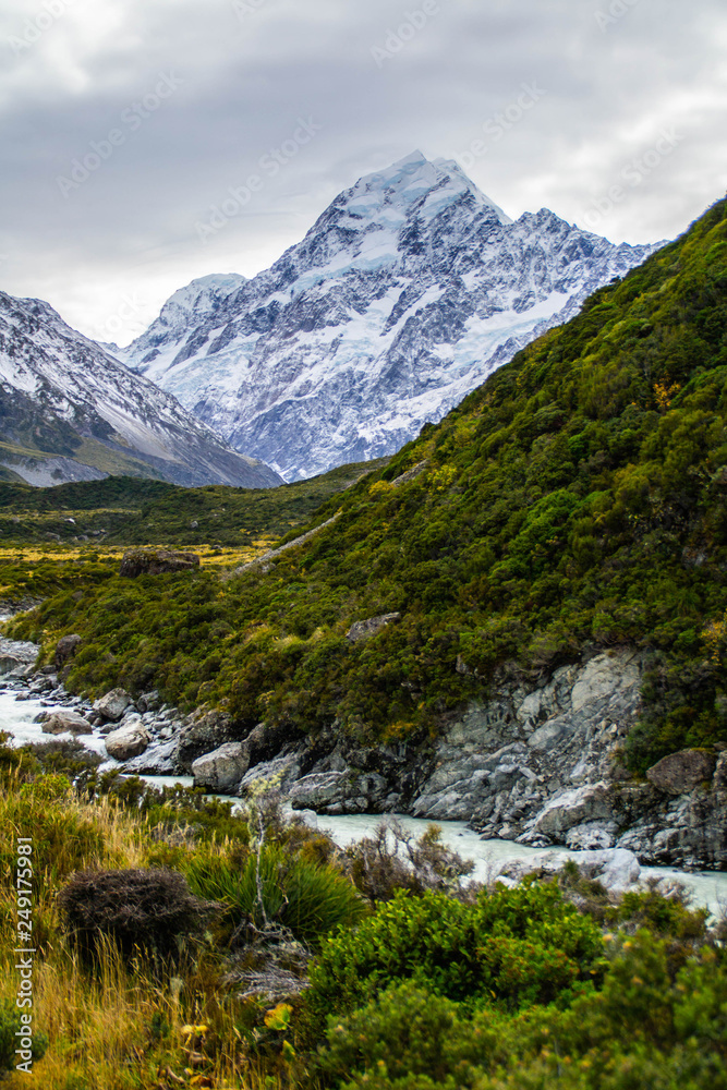 Scenic landscape view of Hooker Valley, Aoraki/Mount Cook National Park, South Island of New Zealand. Snow covered mountains. Tourist (backpackers) popular hiking or walking attraction/destination.