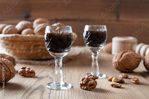 Two glasses of homemade nut liqueur with walnuts