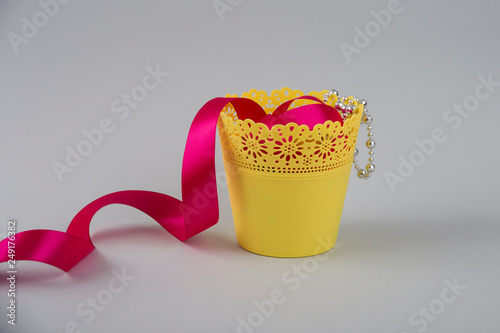 Decorative yellow bucket with a pink ribbon.