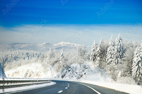 Highway road in winter, mountains covered with snow in Gorski kotar, Croatia in background