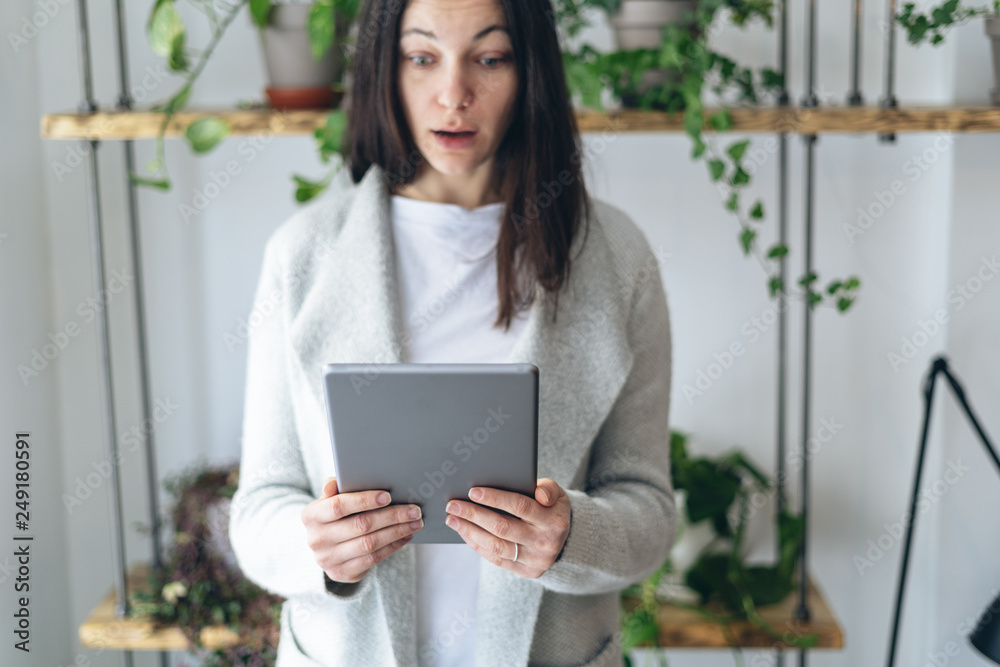 Woman looking at tablet display with worried face Woman looking at tablet display with worried face