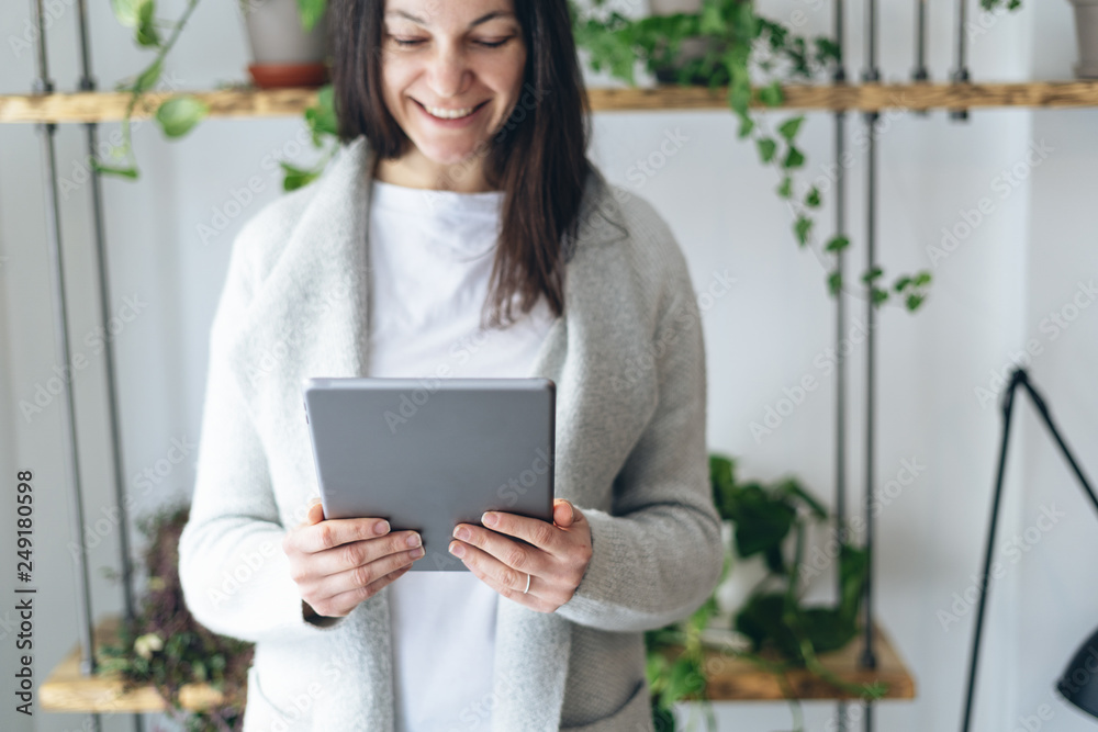 Woman looking at tablet and making beaming smile Woman looking at tablet and making beaming smile