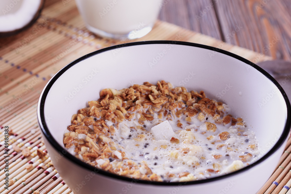 Healthy and tasty granola breakfast with coconut pieces and milk, macro