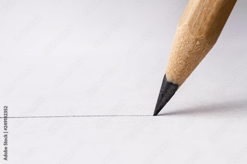 Close up of pencil with drawing line on textured white paper Stock