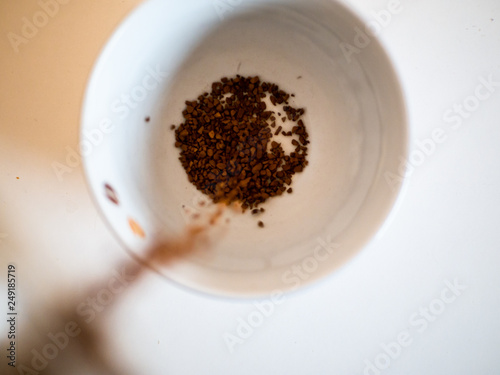 Instant coffee being poured into a coffee mug