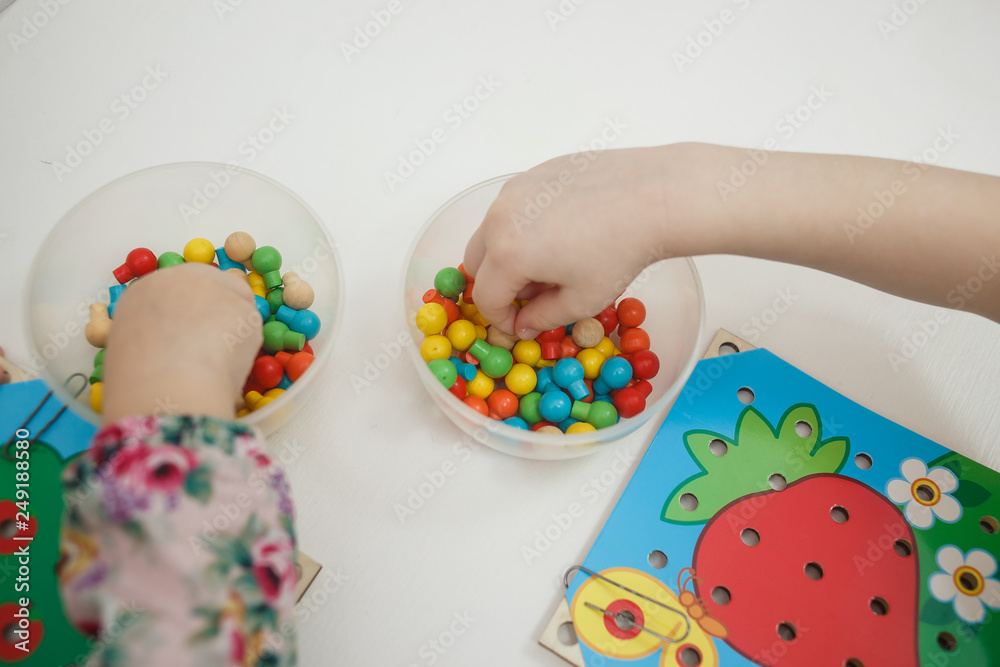 Toddlers playing multicolored educational games, mosaic and puzzles table.