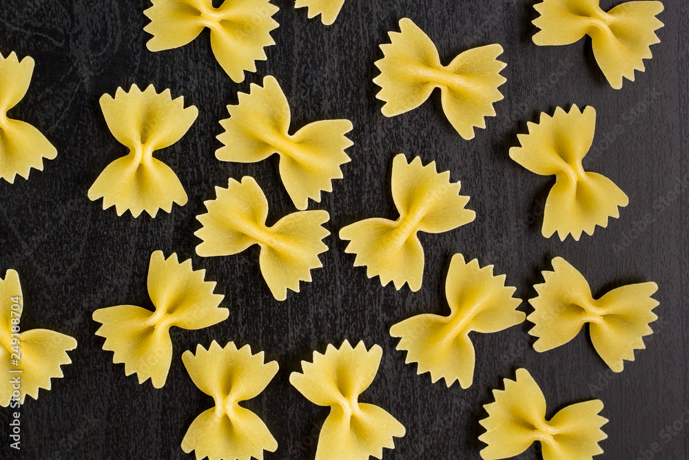 A pile of farfalle pasta on black background