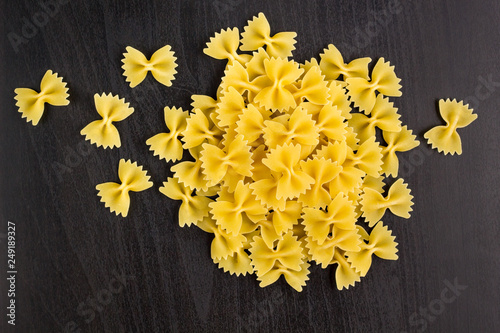 A pile of farfalle pasta on black background