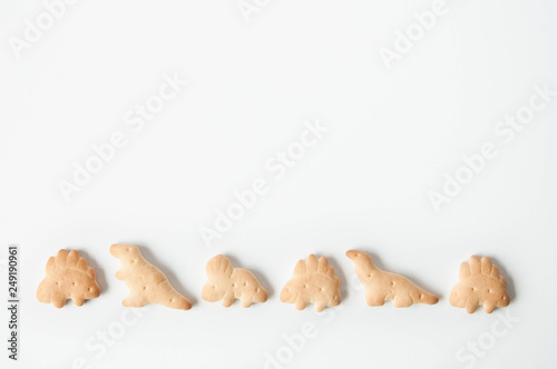 Crackers, baby cookies, dinosaurs on a white background. Baby food. Food snack for school children and toddlers.