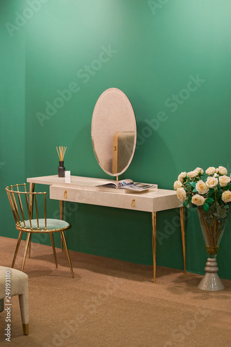 Fotografija White dressing table with wicker elements, a room with a green wall and golden b