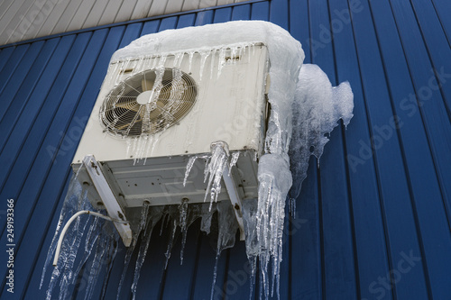 Air conditioning in ice, severe winter. White air conditioner photo