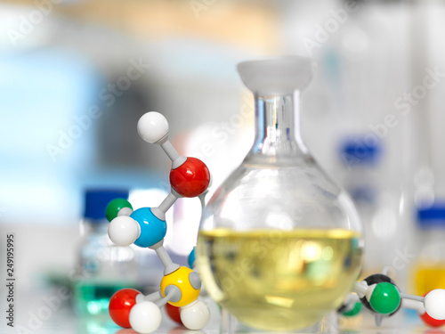 Flask containing a chemical formula next to molecule model