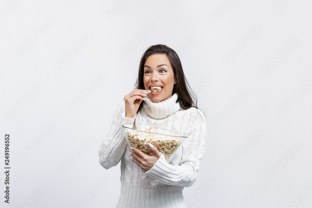 beautiful young woman in a studio eating popcorn beautiful young woman in a studio eating popcorn