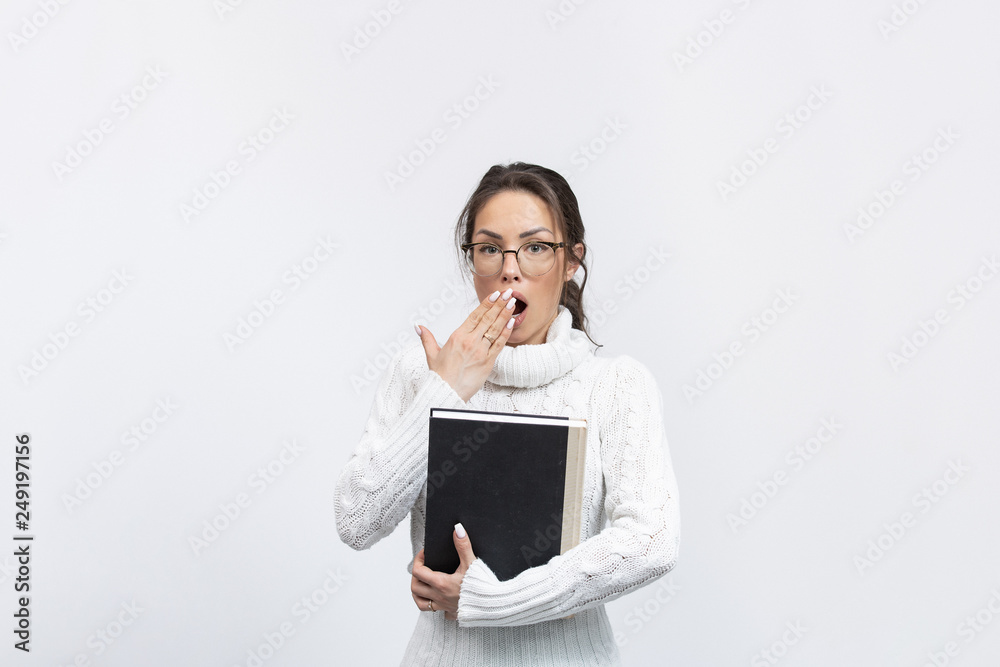 beautiful young surprised woman in a studio with a book and glasses beautiful young surprised woman in a studio with a book and glasses