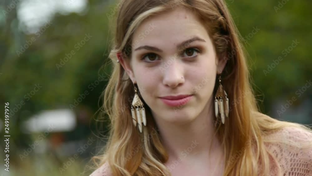 Young Woman Looking Down, Lost In Thought, Looks Up And Smiles Young Woman Looking Down, Lost In Thought, Looks Up And Smiles