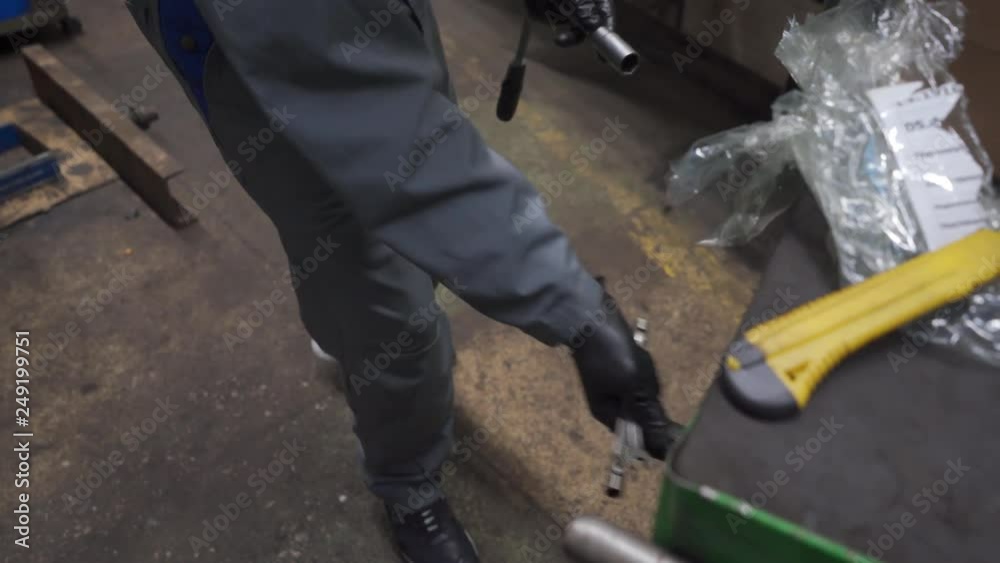a mechanic in a car service picks tools from a green box a mechanic in a car service picks tools from a green box