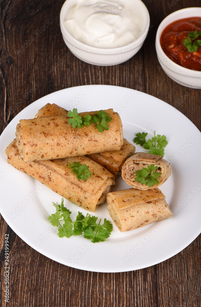 Pancake rolls with meat filling, served with fresh parsley