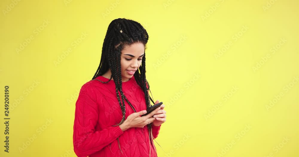 Multi ethnic lady with a long dreadlocks using a smartphone to calling someone in front of the camera in the studio , she have a great mood Multi ethnic lady with a long dreadlocks using a smartphone to calling someone in front of the camera in the studio , she have a great mood