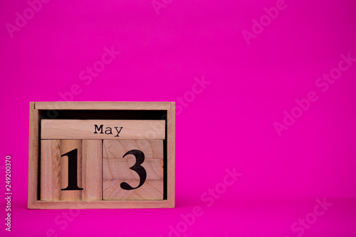 May 13th. Day 13 of may month set on wooden calendar isolated on pink background. Spring time.