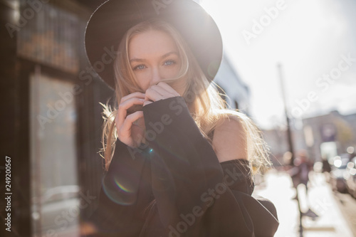 Portrait of woman with hat dressed in black at backlight