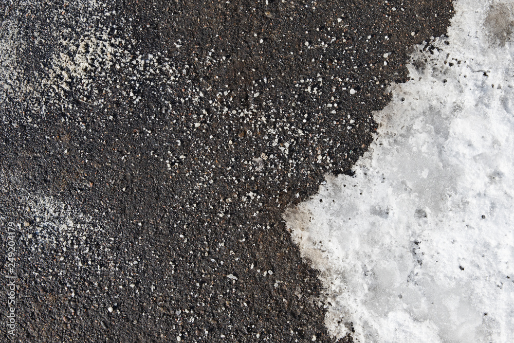 Foto Stock Deicing chemicals on the asphalt road. Pavement is sprinkled with technical salt or