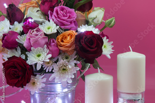 Vase of bouquet Roses and white candlestick lighting bulb and Vase of bouquet Roses. 