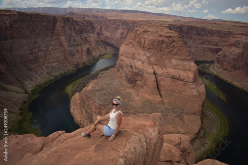 A girl is sitting near the Horseshoe bend