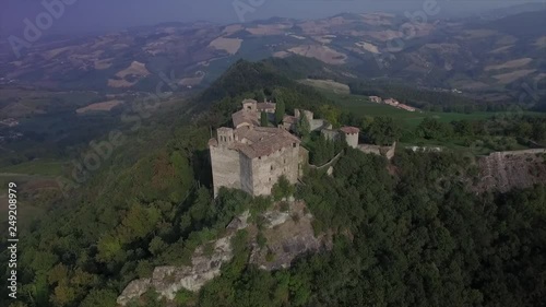 Aerial drone video at sunset time above an ancien building at the top of the hill in the countryside of Piacenza, Italy, near Pianello Val Tidone.