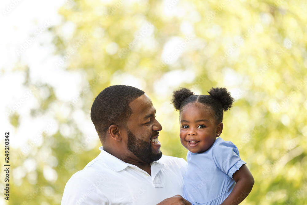 African American father hugging and holding his little girl. African American father hugging and holding his little girl.
