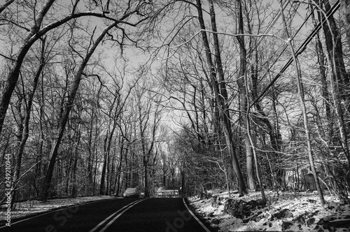 driving on county road on the first day of spring with snow on the ground, black and white