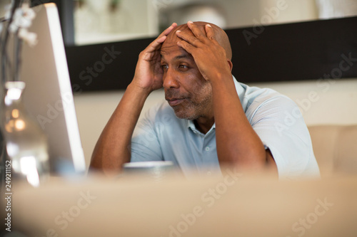 Mature African American man working from his home office. photo