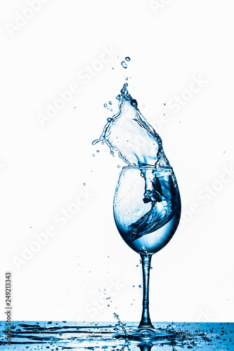 Wineglass With Water Splash and Drops In Motion Against Pure White Background.