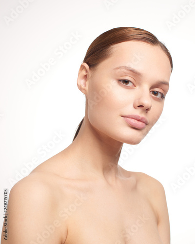 Beauty portrait of young girl with brown hair and big lips on white background with clean face skin and arm near head. Good for cosmetic  medicine and spa . European type