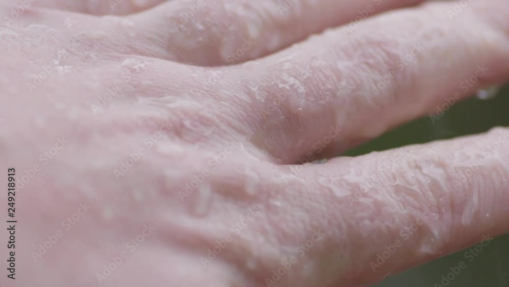 Macro Lens closeup: Rain splashes off adult man's hands and fingers, rainstorm. Macro Lens closeup: Rain splashes off adult man's hands and fingers, rainstorm.