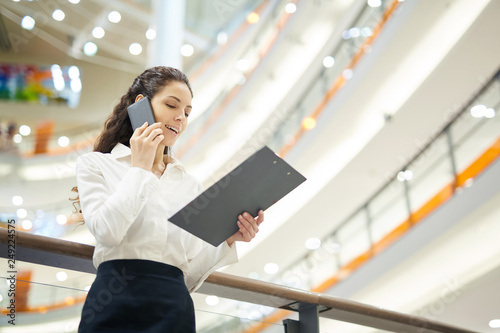 Tableau sur toile Pretty young businesswoman in formalwear reading terms of contract to her client