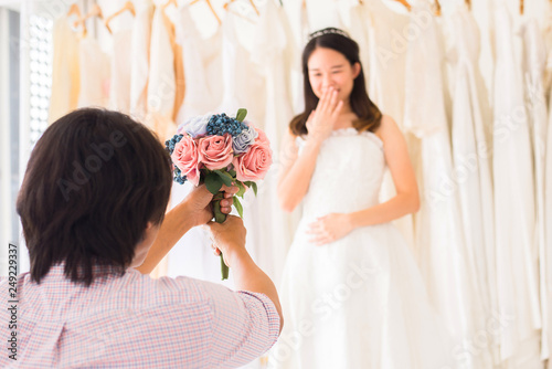 Groom give flower to surprise bride,asain woman positive emotion and face astonished,Romantic and sweet moment photo