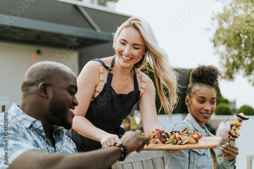 Woman serving her friends vegan barbeque skewers