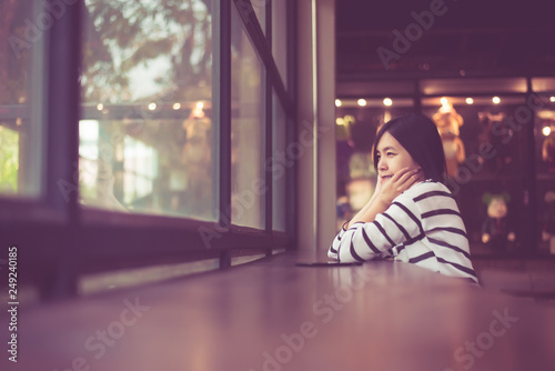 Asian beautiful woman sittiing and looking something out of window at coffee shop cafe,Happy and smiling,Positive thinking photo