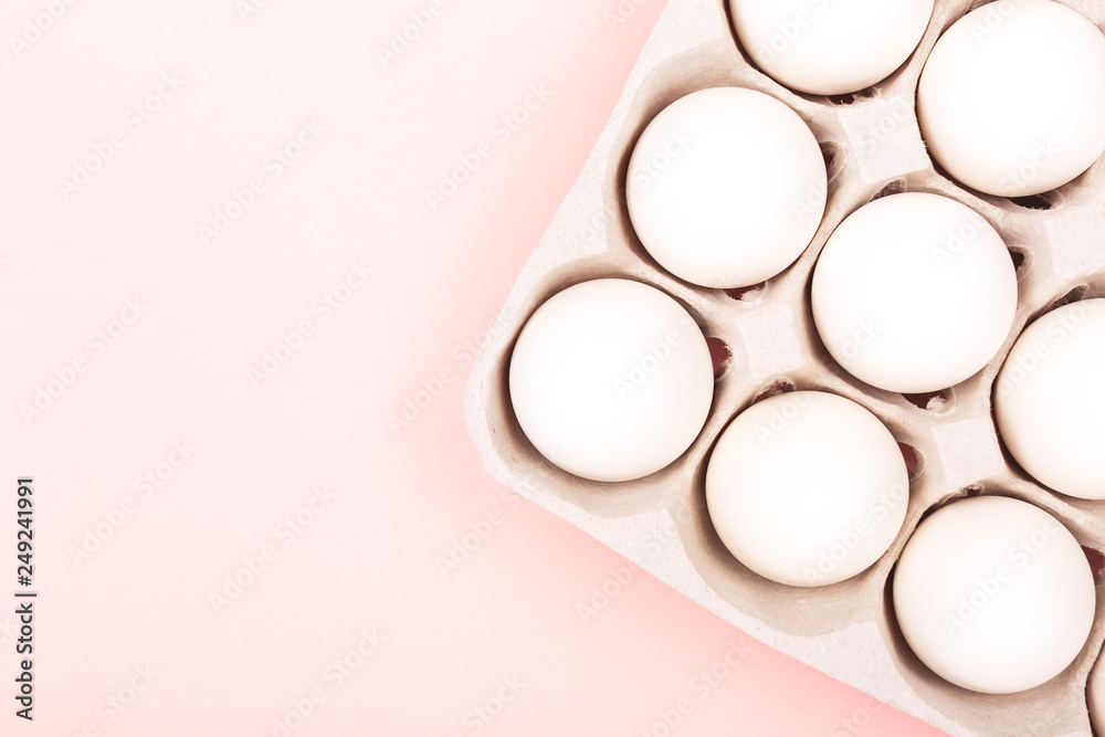 Eggs in egg box on pink background