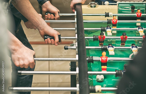 Guys are playing table soccer indoor