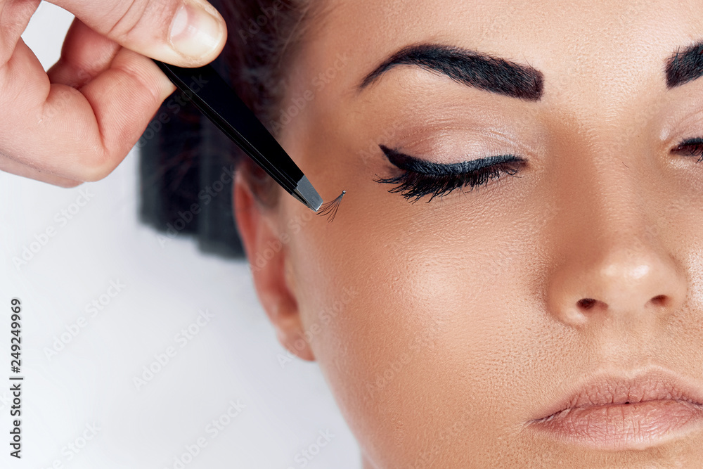 Beautiful Woman with long eyelashes in a beauty salon. Eyelash extension procedure. Lashes close up. Cosmetics and makeup. Close Up macro shot of fashion eyes visage