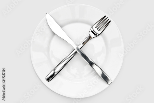 fork and knife, lying cross on a white plate