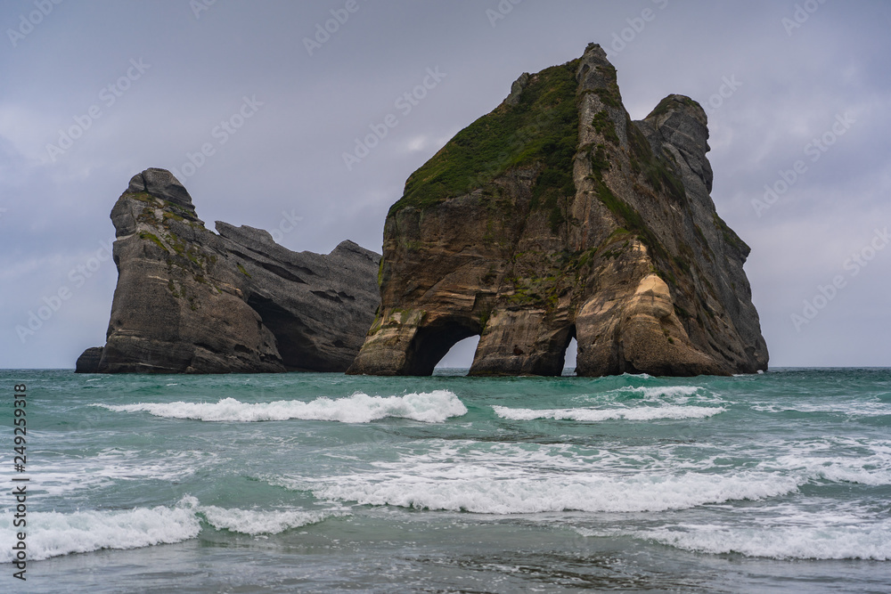 Fototapeta premium Rippled Sand and rock formations at Wharariki Beach, Nelson, North Island, New Zealand, Archway Islands, Natural wallpaper background, landscape photography, amazing stone formation