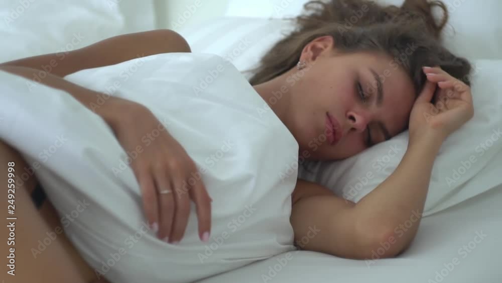 Beautiful young woman sleeping peacefully on her side, her hair spread out on the pillow, the body barely covered with a blanket, Beautiful young woman sleeping peacefully on her side, her hair spread out on the pillow, the body barely covered with a blanket,