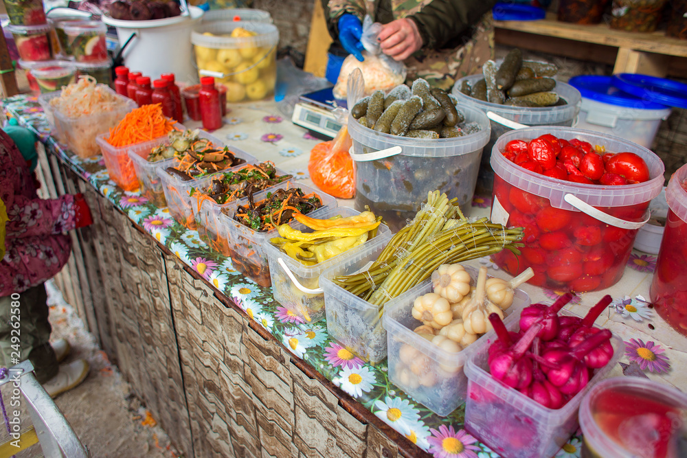 Counter with fermented vegetables in the market in Russia. Sale of salads from the salted vegetables