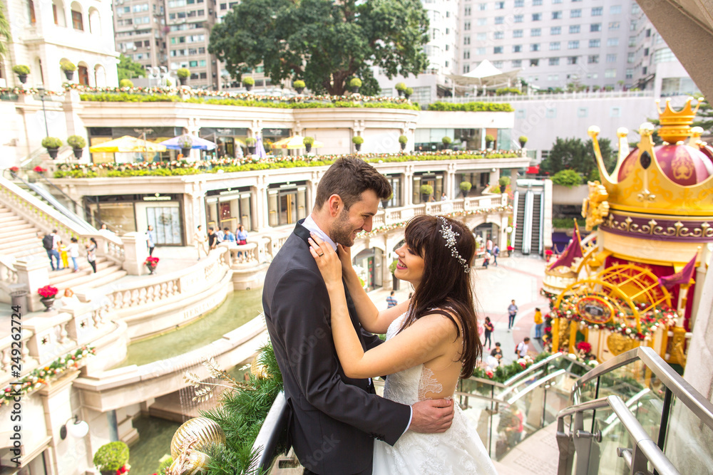 Wedding couple posing in new mall in Hong Kong Wedding couple posing in new mall in Hong Kong