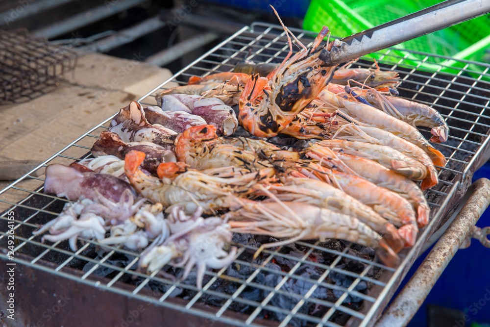 Professional Chef Cooking  Prawns or shrimp grilled on charcoal stove. shrimp grilled bbq seafood on stove.Closed up river prawn charcoal grilled on stove with Thai style homemade.