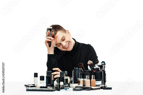 Professional makeup artist with tools isolated on white studio background. The man in female proffesion. gender equality concept