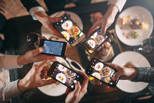 Group of friends going out and taking a photo of food together with mobile phone photo